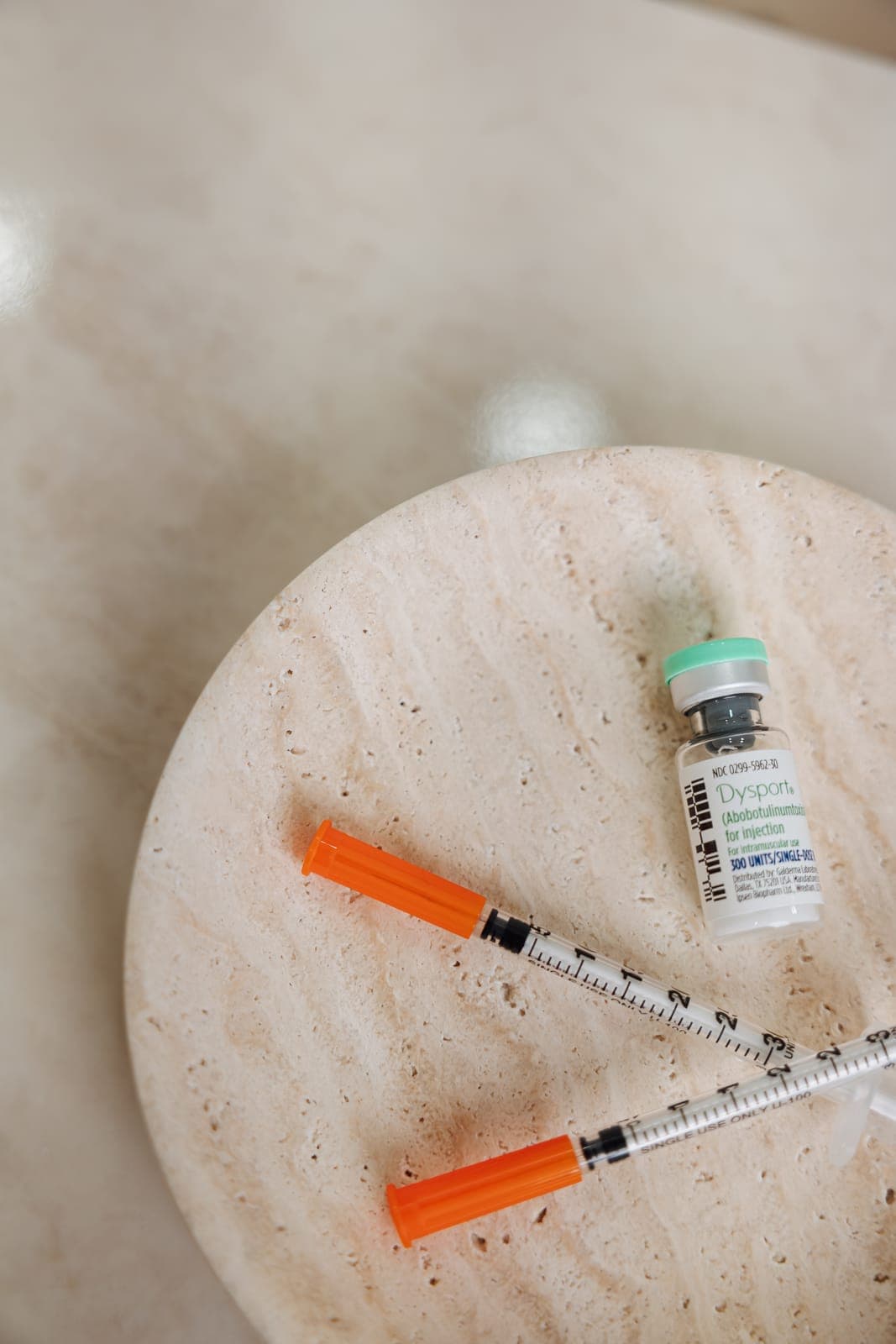 A vial of Dysport and treatment syringes on a marble tray at Tailored Wellness & Aesthetics in Miami